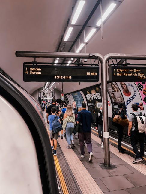 The Finsbury Park train station platform during daytime with a clean, well-maintained surface. The platform is covered by a beige, corrugated metal roof supported by grey metal columns. Multiple metal